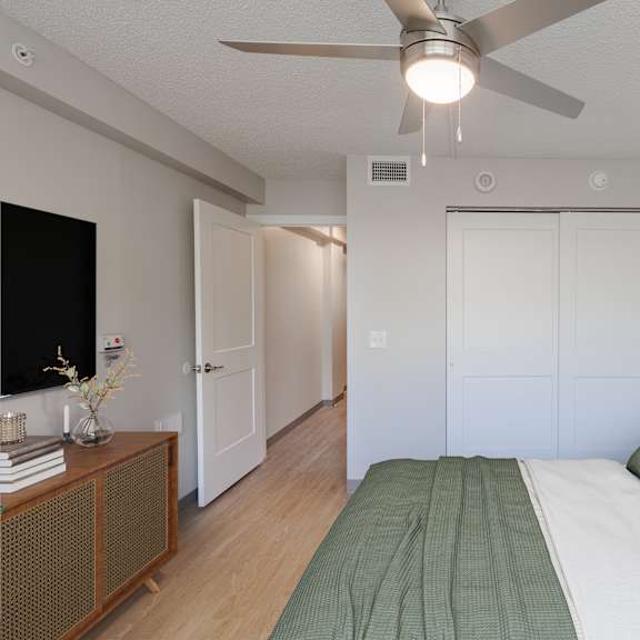 A living room with a white couch, a coffee table, and a flat screen TV.