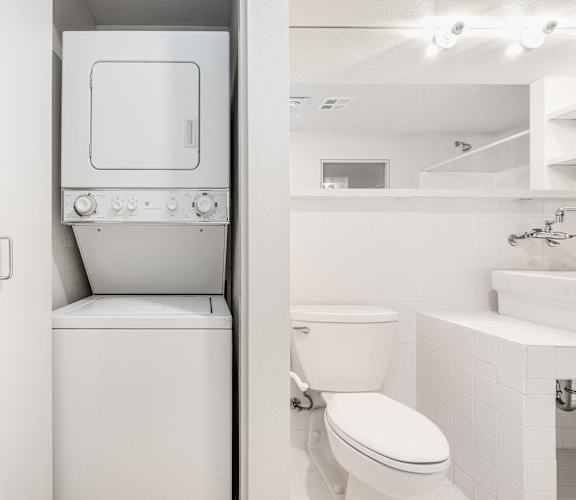 a bathroom with a toilet and a washer and dryer