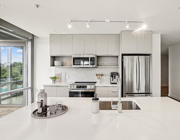 a kitchen with white counter tops and a sink