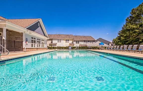 our apartments have a large pool with chairs and umbrellas at The Atlantic Mountain Island, Charlotte, NC