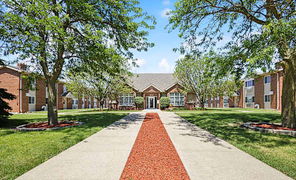 a sidewalk in front of a building with trees