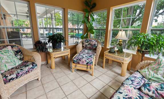 A sunroom with a couch, chair, and table.