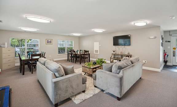 the living room and dining room with couches and a tv