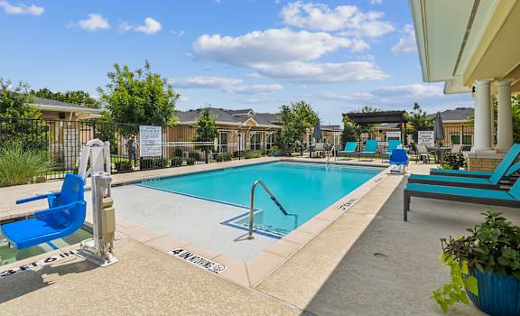 our apartments have a swimming pool with blue chairs