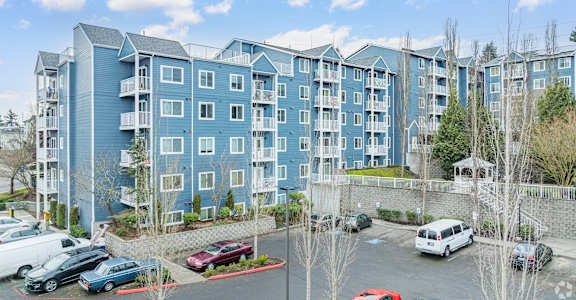 A large blue apartment building with a parking lot in front  at Vintage at Everett Senior Community, Everett, Washington