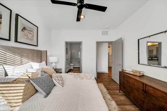 a bedroom with a large bed and a ceiling fanat The BLVD at Wilson Crossings, Wyoming, MI
