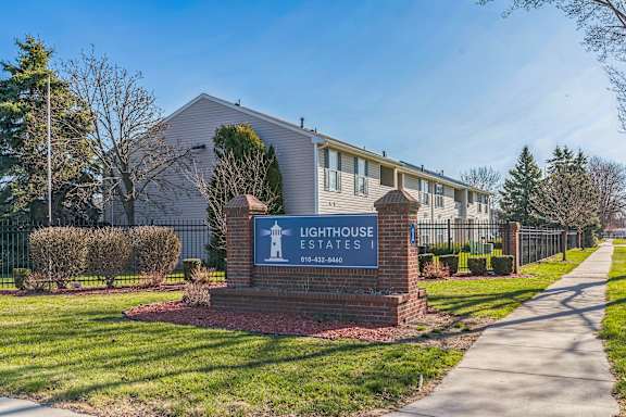 A sign for Lighthouse Estates is in front of a building.
