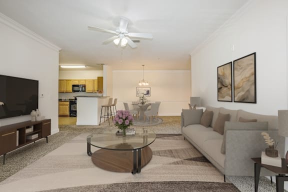 A living room with a grey couch, a glass coffee table, and a television at Stone Gate Apartments, Spring Lake, North Carolina