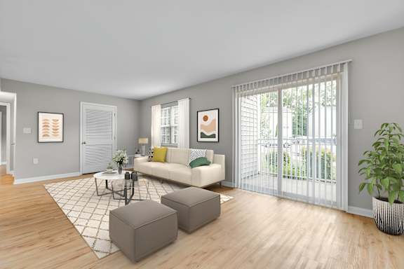 A living room with a white couch, a coffee table, and a potted plant. at West Pointe Apartments, Apartments, Burlington, NC