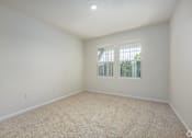 Thumbnail 15 of 20 - A room with a carpeted floor and a window with bars.
