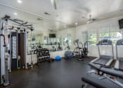 Thumbnail 6 of 20 - A gym with treadmills, weights, and exercise equipment.