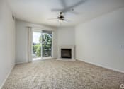 Thumbnail 12 of 20 - A room with a carpet floor, a ceiling fan, and a fireplace.