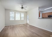 Thumbnail 13 of 20 - A room with a ceiling fan and wooden flooring.