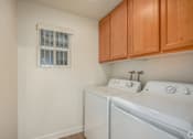 Thumbnail 14 of 20 - A small laundry room with a washer and dryer.