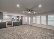 Thumbnail 16 of 30 - Modern open-concept living room with ceiling fan and wood-style floors at Reserve on Abrams Dallas
