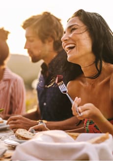 A group of people enjoying a meal together outdoors. at Tides on East Cactus Apartments, Phoenix