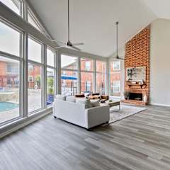 A modern kitchen with a white sofa and grey flooring.