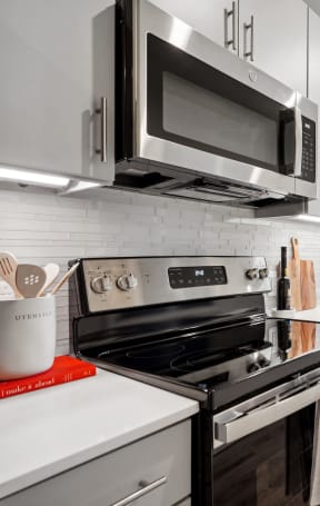 a kitchen with white cabinets and stainless steel appliances and a microwave at Sinclaire on Seminary, Alexandria, VA