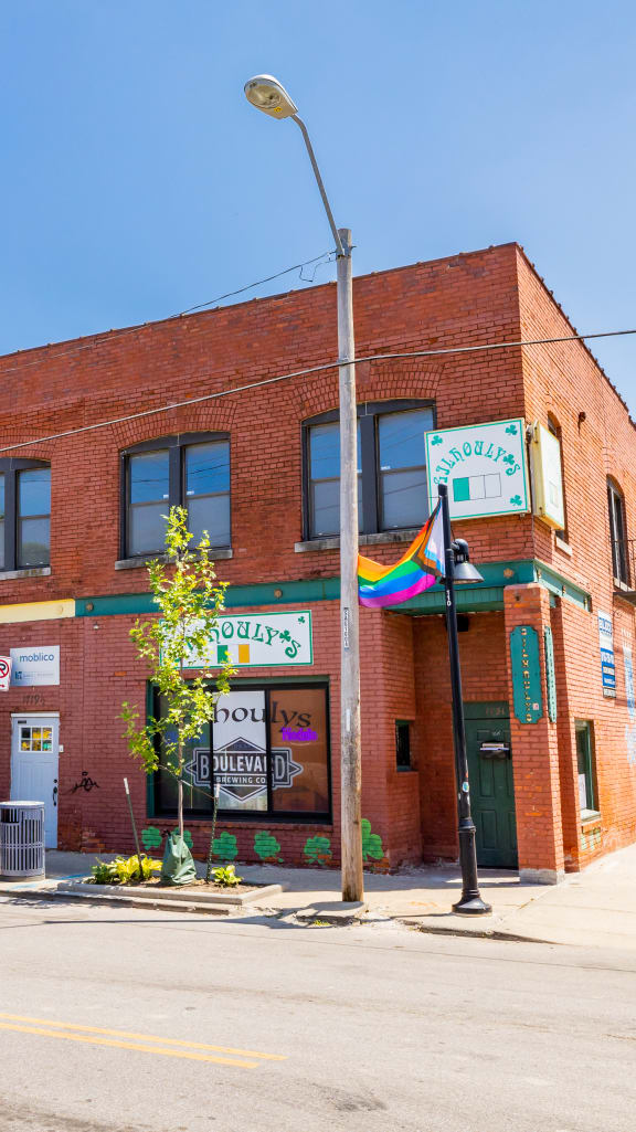a brick building with a rainbow flag in front of it