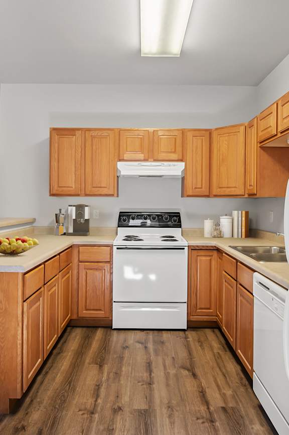 A kitchen with wooden cabinets and white appliances.
