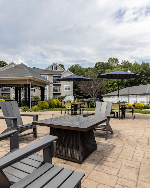 a patio with a table and a window overlooking a lake