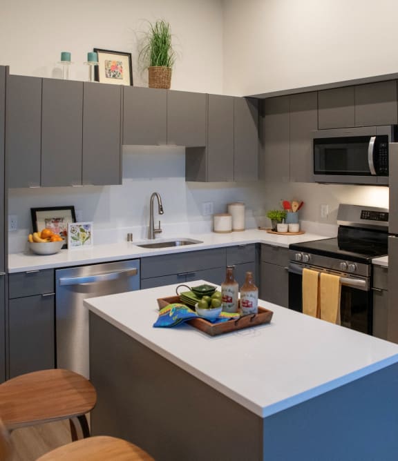 an open kitchen with a view of a living room and a bedroom