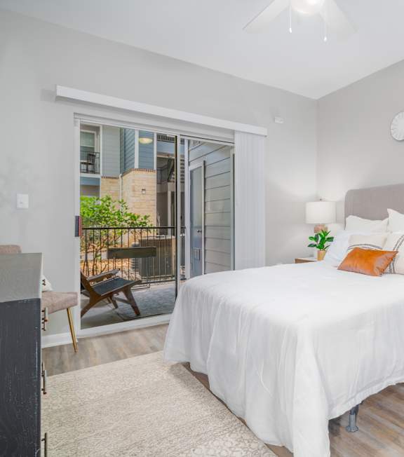 A bedroom with a large bed and a ceiling fan.