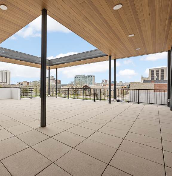 A patio with a wooden roof and tiled floor.