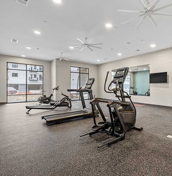 A spacious gym with treadmills and elliptical machines.