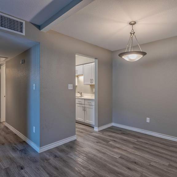 A room with a wooden floor and a hanging light fixture.