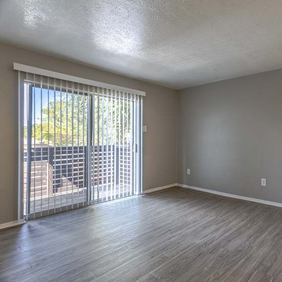 A room with a sliding glass door leading to a balcony.