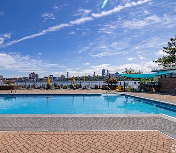 A swimming pool with a city skyline in the background.