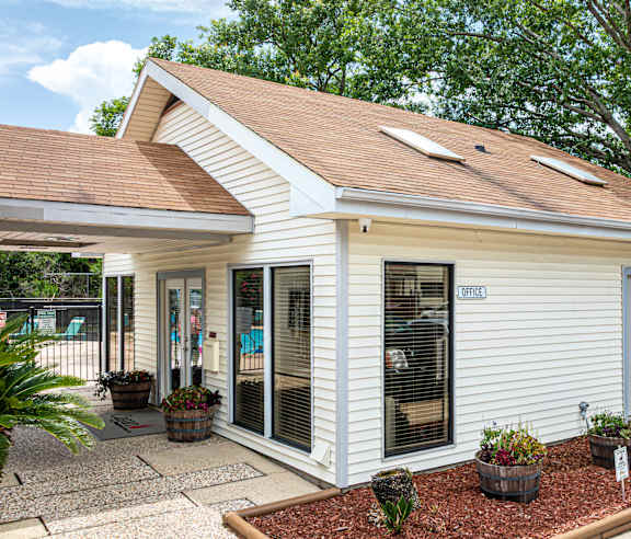 A small white building with a brown roof and a sign that says "EXIT".
