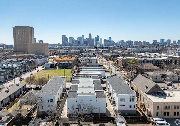 A cityscape with apartment buildings in the foreground and a city skyline in the background.
