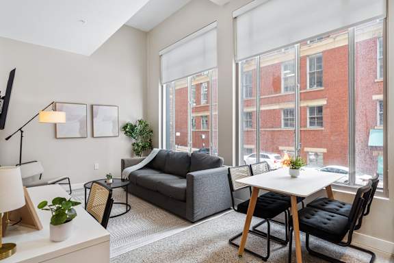 a living room with large windows and a couch and a table