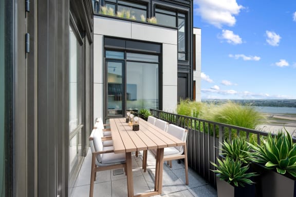 a patio with a wooden table and chairs on a balcony
