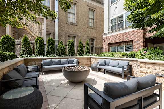 A patio with black furniture and a fire pit.