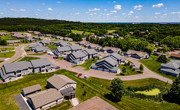 A bird's eye view of a residential area with houses and green lawns.