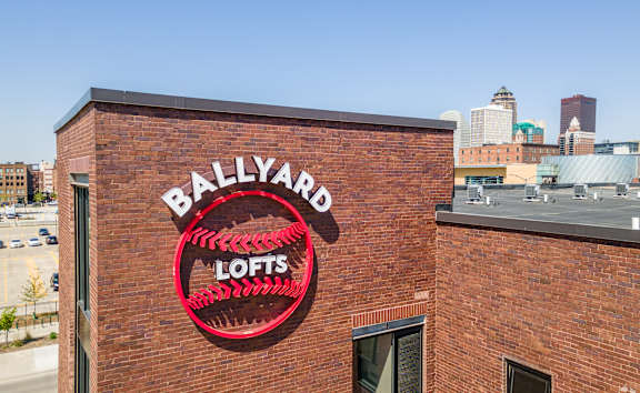 A red sign on a brick building that says Ballyard Lofts.