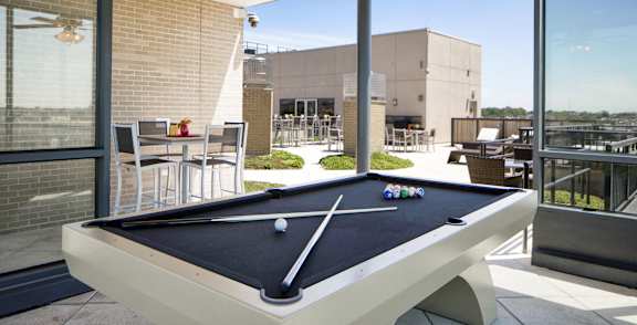 a pool table in a patio area with a ceiling fan