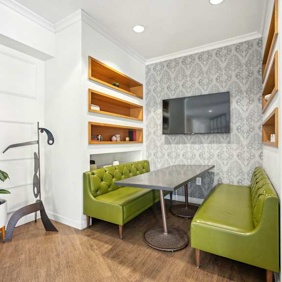 A living room with a green couch and a television.