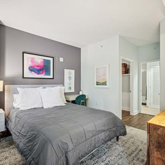 A bedroom with a large bed and a painting on the wall.
