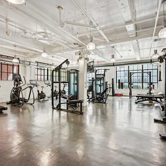 A gym with treadmills, exercise bikes, and other equipment.
