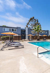 a swimming pool with a table and umbrella at Fiesta Apts, Lompoc, 93436