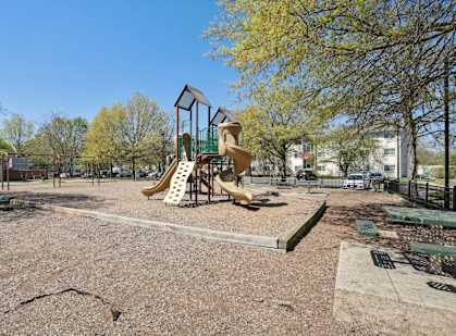 A playground with a slide and a swing set.
