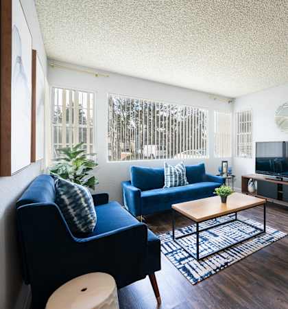 a living room with blue couches and a tv