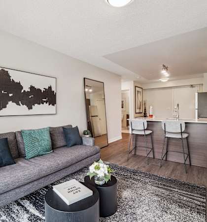 a living room with a couch and a kitchen in the background