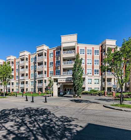A large apartment complex with a parking lot in front.