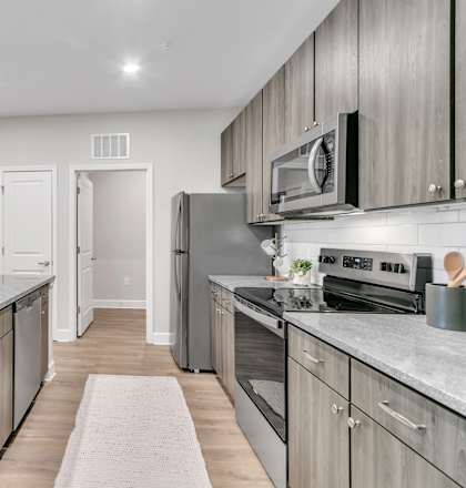 A modern kitchen with a white sink and grey countertops.