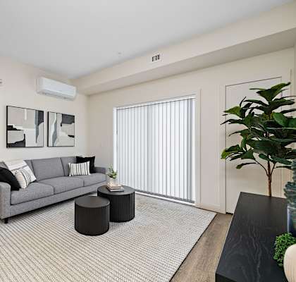 A living room with a grey couch and a white wall.at The Fifth at Palisades, Edmonton, AB, T6V 0N5